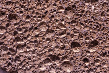 Fotoğrafta delikleri olan turuncu taştan sünger taşının güzel dokusu var.