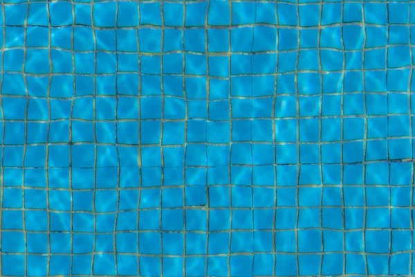 Hermosa textura de agua con luces solares en una piscina sobre el fondo azul de textura de baldosas pequeñas de cerámica cuadrada —  Fotos de Stock