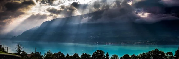 Güzel mavi göl ve İsviçre 'de Alpler' de kahverengi çatıları olan evler gün ışığında. — Stok fotoğraf