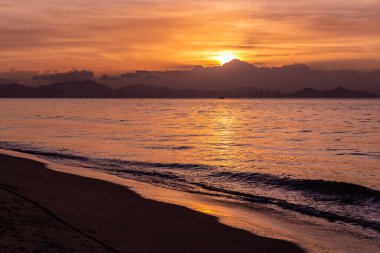 Güzel turuncu gün doğumu deniz kıyısında.