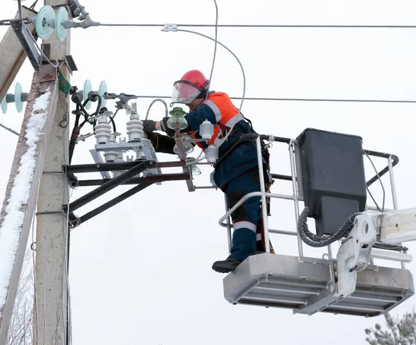 Electricista conecta los cables al aislador de línea Imágenes de stock libres de derechos