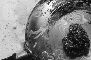 Tencerede deterjanlı metal bir kazıyıcı ile ngara temizlemek