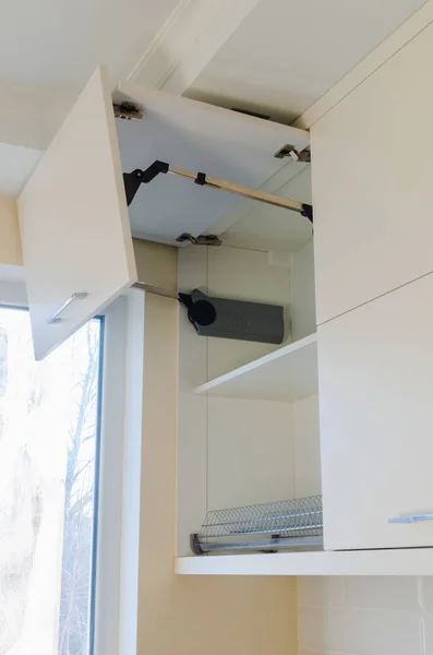 Lemari dinding dapur dengan fasad MDF dan mekanisme pembukaan lipat dengan warna krem terang . — Stok Foto