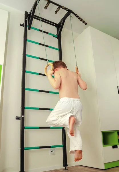 Little boy of preschool age does morning exercises on a home horizontal bar — Stock Image Little boy of preschool age does morning exercises on a home horizontal bar Royalty Free Stock Images