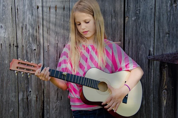 Teenie-Mädchen spielt Gitarre in Sonnenstrahlen — Stockfoto