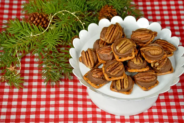 Pecans on melted chocolate candy with pretzels — Stock Photo, Image