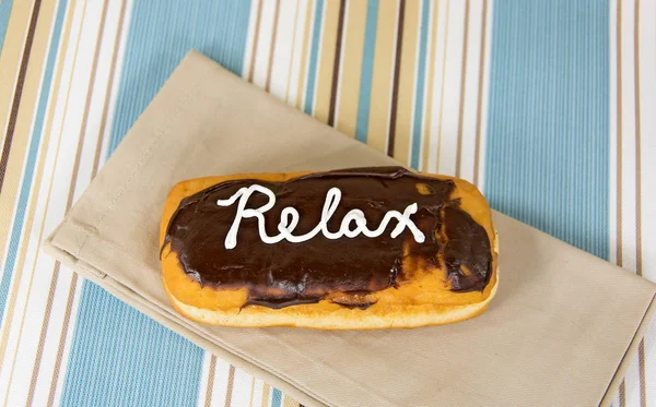 Word relax on chocolate donut — Stock Photo, Image