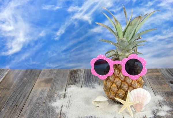 Ananas bär Rosa solglasögon med sjöstjärnor — Stockfoto