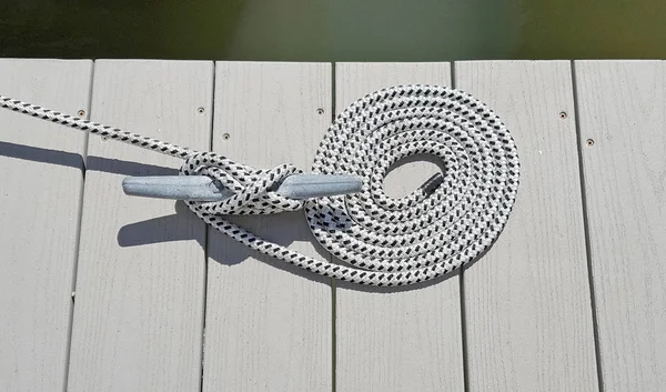 Nautical rope tied to dock cleat — Stock Photo, Image