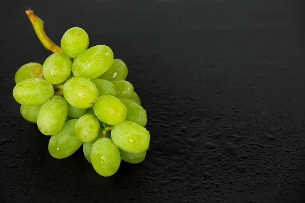 Uvas verdes molhadas em ardósia preta — Fotografia de Stock