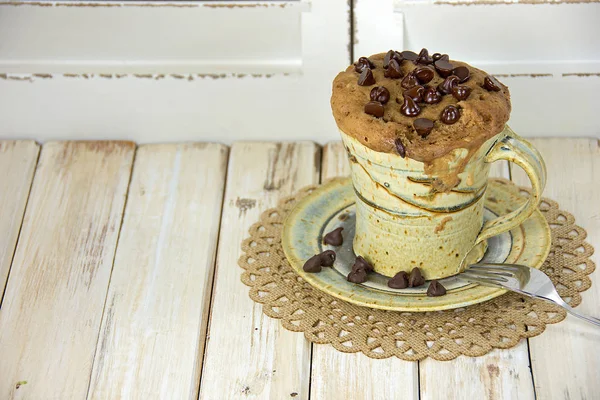 Muffin de chispas de chocolate en taza de café con tenedor — Foto de Stock