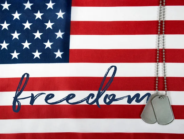 Word freedom and dog tags on flag — Stock Photo, Image