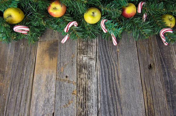 Äpfel und Zuckerstangen im Weihnachtskranz — Stockfoto