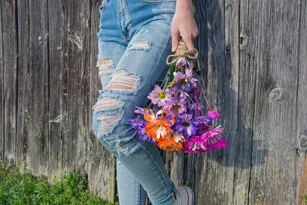Девушка-подросток в обветренных джинсах и маргаритке — стоковое фото
