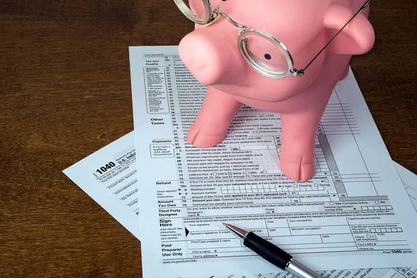 Piggy bank op 1040 inkomstenbelasting formulier — Stockfoto