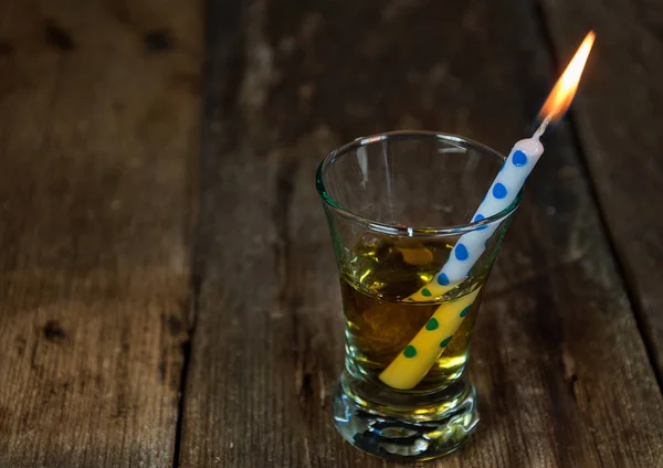 Birthday candle in shot glass — Stock Photo, Image