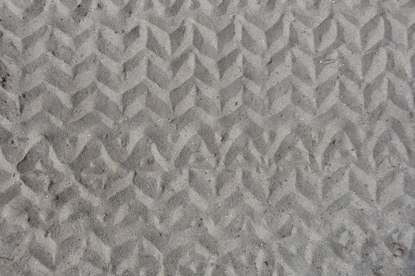 zigzag tire track pattern in dirt