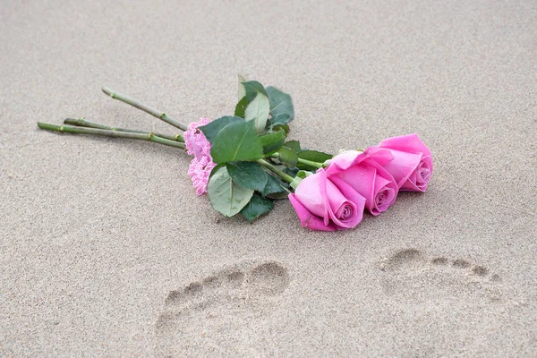 Rosas rosa na areia da praia molhada — Fotografia de Stock