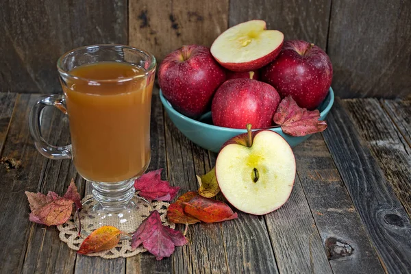 Яблочный сидр с осенними листьями и яблоками — стоковое фото