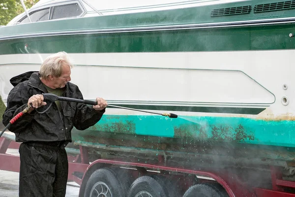 Man cleaning boat with pressure washer — Stock Photo, Image