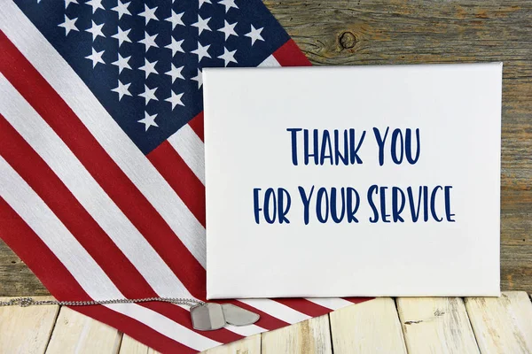 military dog tags on flag with thank you sign