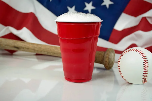 Cerveja em copo vermelho com beisebol e bandeira americana — Fotografia de Stock