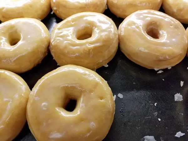 Glazed donuts on bakery shelf — Stock Photo, Image