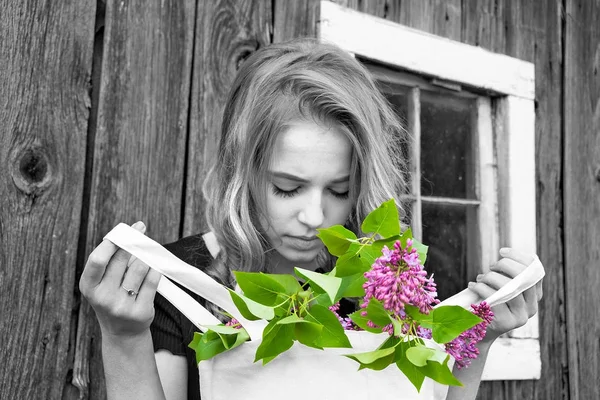 選択的な色の効果で素朴な納屋で春のライラックの花の袋を保持している白人の 代の少女 — ストック写真