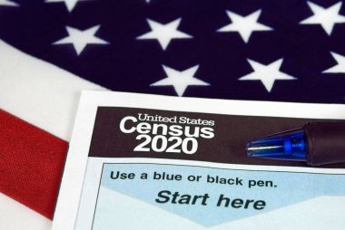 close up of 2020 census document form and ballpoint pen on American flag clipart