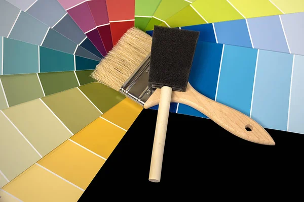 foam brush and paint brush tools on colorful paint chips