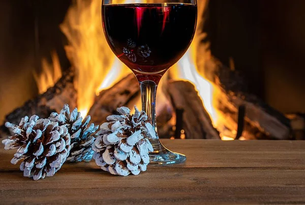 Glass Red Wine Fireplace Christmas Frosted Pine Cones — Stock Photo, Image