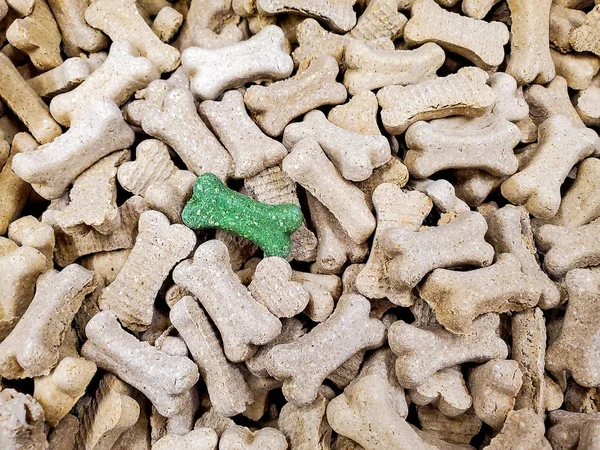 green dog bone biscuit in pile of pet milk bones treats