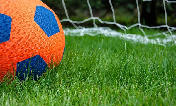 Close Orange Soccer Ball Grass Net Background — 스톡 사진