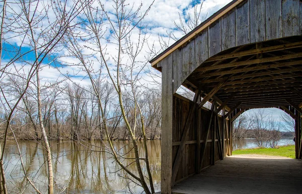 春に川沿いの素朴な木の屋根付きの橋 — ストック写真