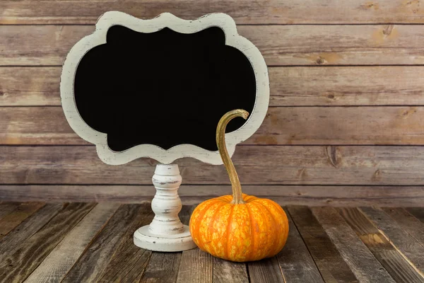 Ornamental gourd with a blank chalkboard sign — Stock Photo, Image