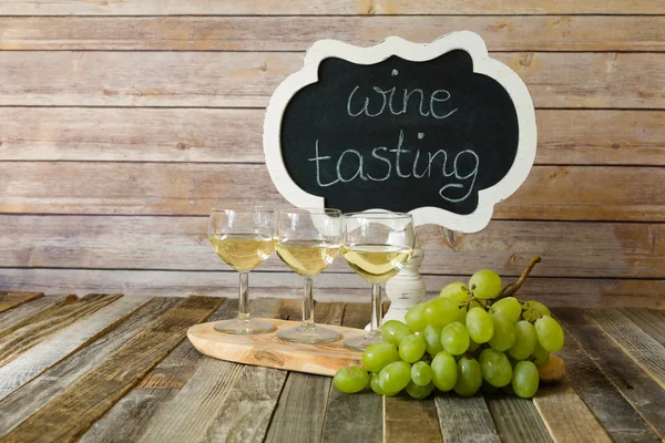 White wine flight with chalkboard sign and grapes — Stock Photo, Image