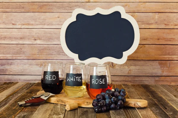Τριών χρωμάτων κρασί πτήσης σε μαυροπίνακα ποτήρια με ένα σύμβολο — Φωτογραφία Αρχείου