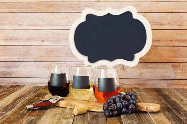 Τριών χρωμάτων κρασί πτήσης σε μαυροπίνακα ποτήρια με ένα σύμβολο — Φωτογραφία Αρχείου