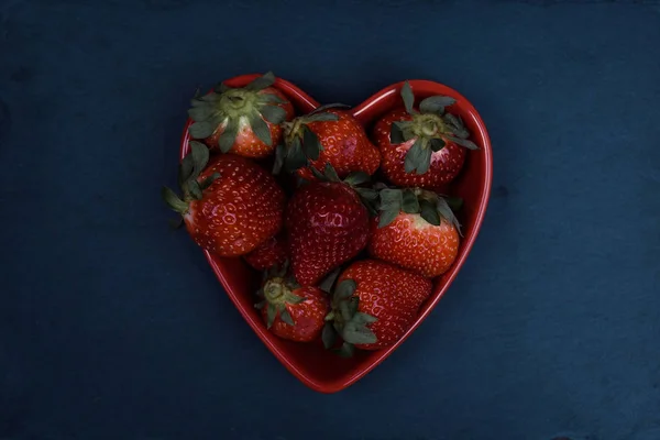 Cuenco en forma de corazón de fresas sobre fondo de pizarra —  Fotos de Stock