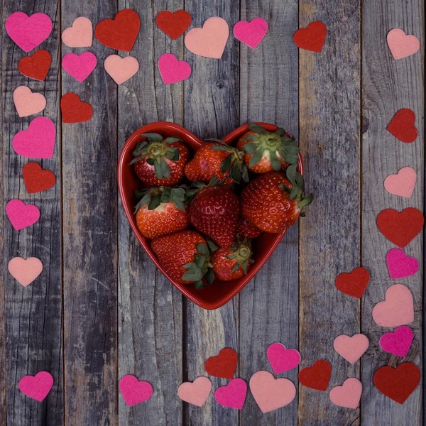 Cuenco en forma de corazón de fresas sobre fondo de madera — Foto de Stock