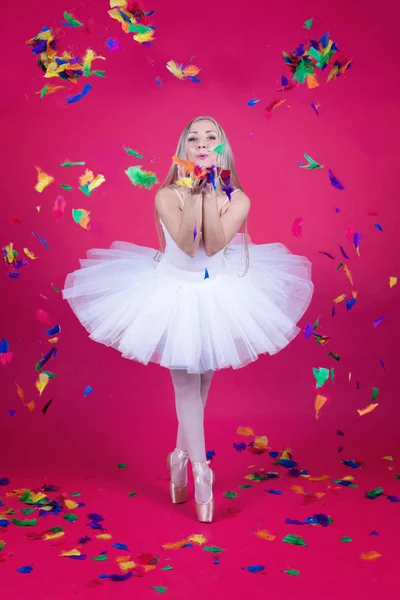 Bailarina en falda tutú soplando plumas — Foto de Stock