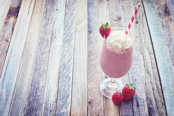 Delicioso batido de fresa sobre fondo de madera — Foto de Stock