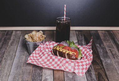 Cips ve içecek şemsiye ile sepet içinde gurme sosisli na