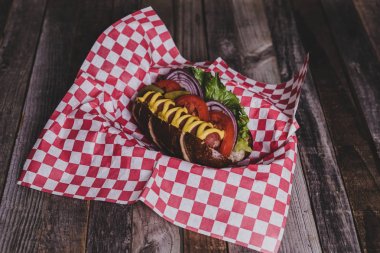 Koyu arka plan üzerine Topingler ile klasik sosisli sandviç.