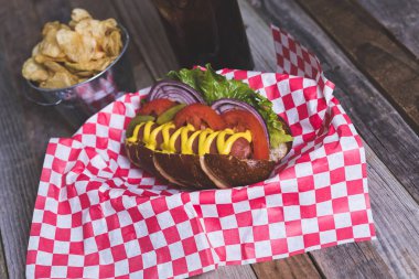 Cips ve içecek şemsiye ile sepet içinde gurme sosisli na