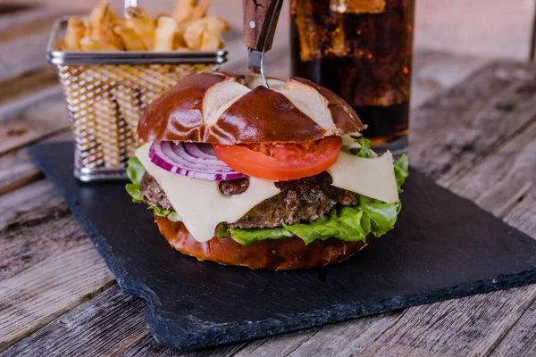 Hamburguesa gourmet con queso y papas fritas y bebida Imagen de stock