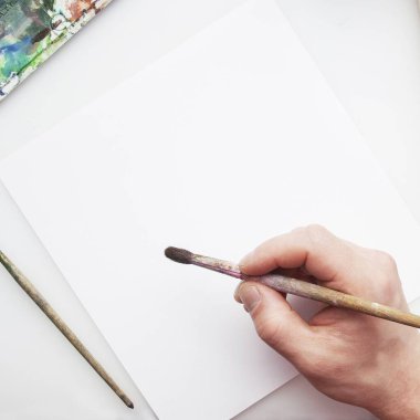 Yaratıcı bir meslek. Beyaz üzerinde fırça ve suluboya bulunan sanatçı işyeri çerçevesi. Mesaj için yer var. Uzayı kopyala Düz yatıyordu. Üst Manzara. Model.