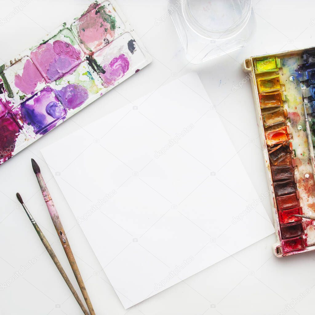 Paints Flat lay. Empty white page with copy space. Frame of artist workplace with brushes and watercolor isolated on white. Space for text. Copy Space.  Flat lay. Top view. Mock up.