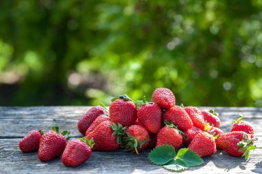 Sulu çilek Çilek güneşin bir tahta üzerinde dağılmış