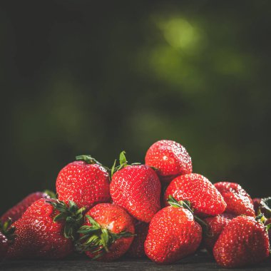 Sulu çilek Çilek güneşin bir tahta üzerinde dağılmış